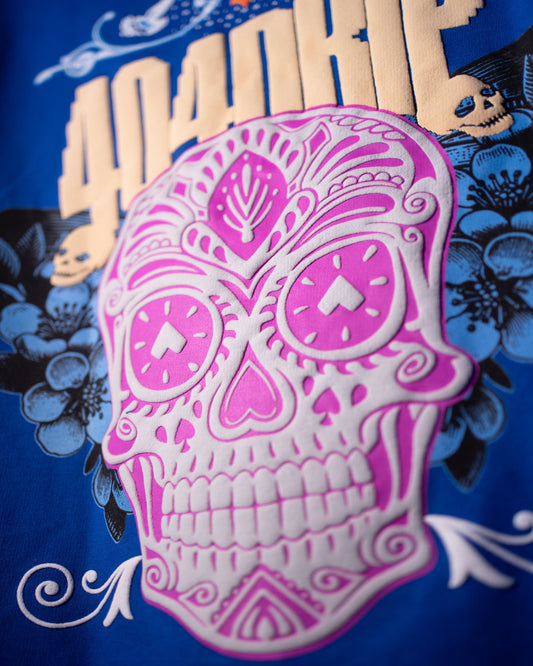 Pink sugar skull design on a blue background with floral elements